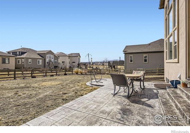 view of patio / terrace with outdoor dining area, fence, and a residential view