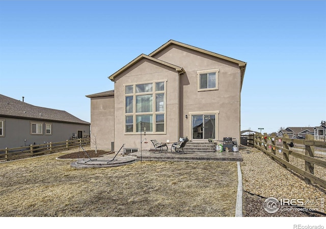 back of house featuring a patio area, a fenced backyard, and stucco siding