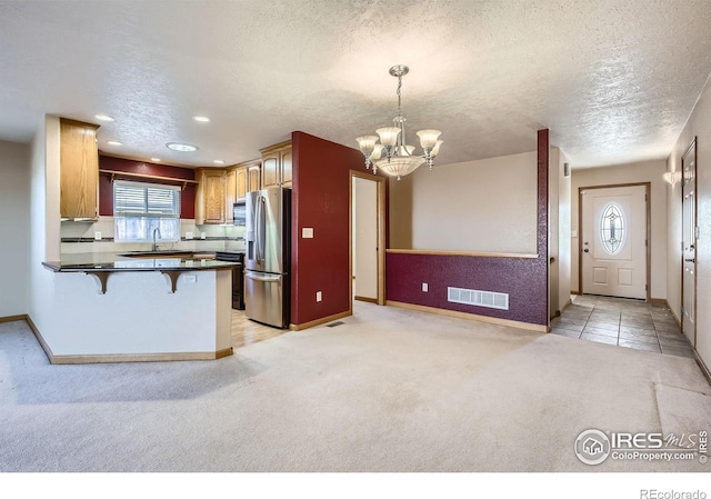 kitchen featuring light carpet, visible vents, a peninsula, stainless steel refrigerator with ice dispenser, and a sink