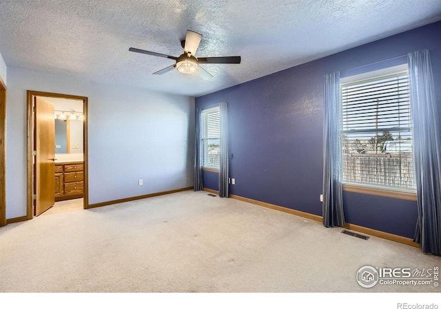 unfurnished bedroom with baseboards, visible vents, carpet flooring, and multiple windows