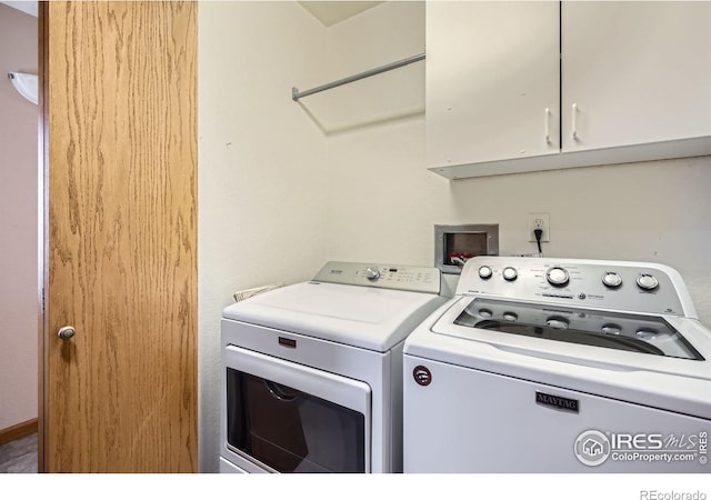 clothes washing area featuring cabinet space and separate washer and dryer