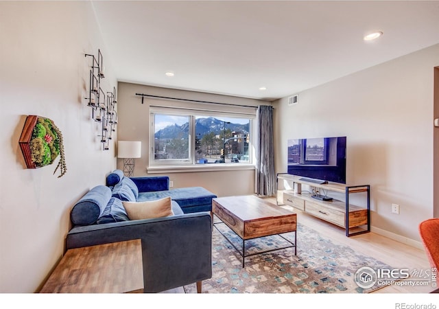 living room featuring recessed lighting, baseboards, visible vents, and wood finished floors