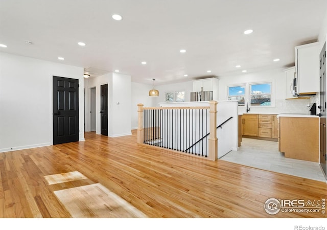 unfurnished room featuring light wood-style flooring, baseboards, and recessed lighting