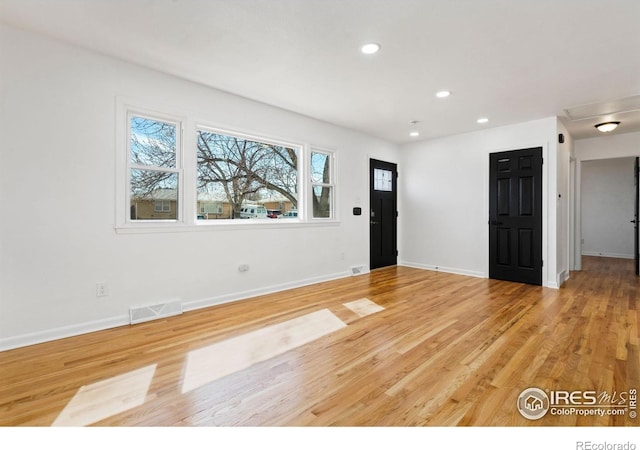 interior space with baseboards, light wood finished floors, visible vents, and recessed lighting