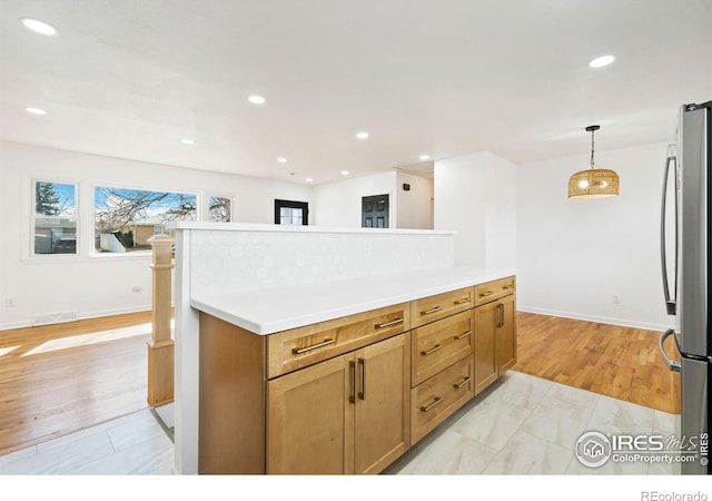 kitchen with freestanding refrigerator, pendant lighting, light countertops, and recessed lighting