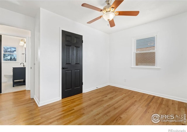 unfurnished room featuring light wood finished floors, a ceiling fan, and baseboards