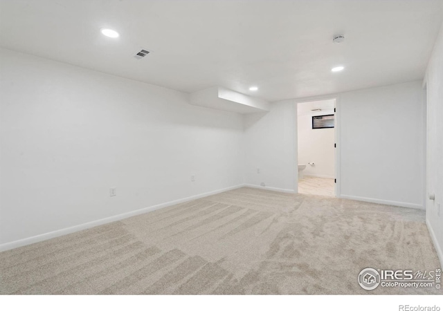 spare room featuring carpet, visible vents, and recessed lighting