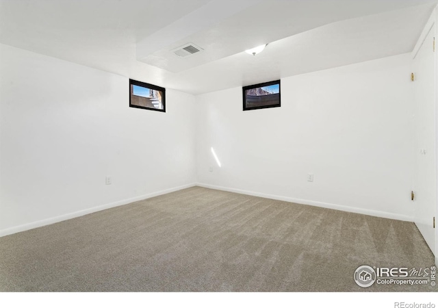 unfurnished room featuring carpet floors, visible vents, and baseboards