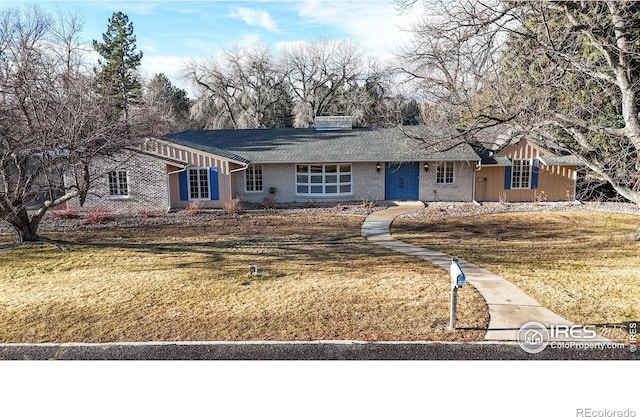 single story home with brick siding and a front lawn