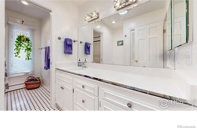 bathroom featuring a baseboard heating unit and vanity