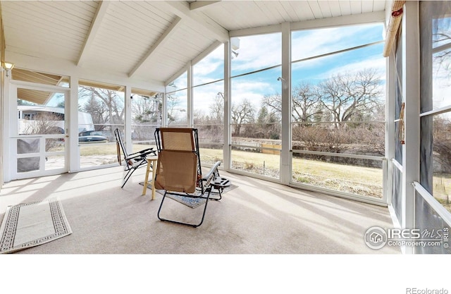 sunroom / solarium featuring vaulted ceiling with beams