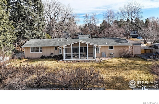 rear view of house with a sunroom, a lawn, and a chimney