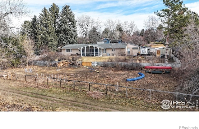 back of house with fence and a sunroom