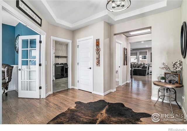 entryway featuring baseboards, a raised ceiling, and wood finished floors