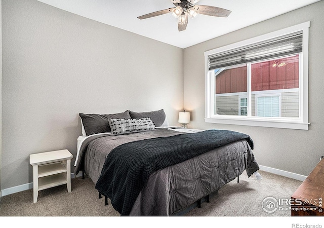 carpeted bedroom with ceiling fan and baseboards