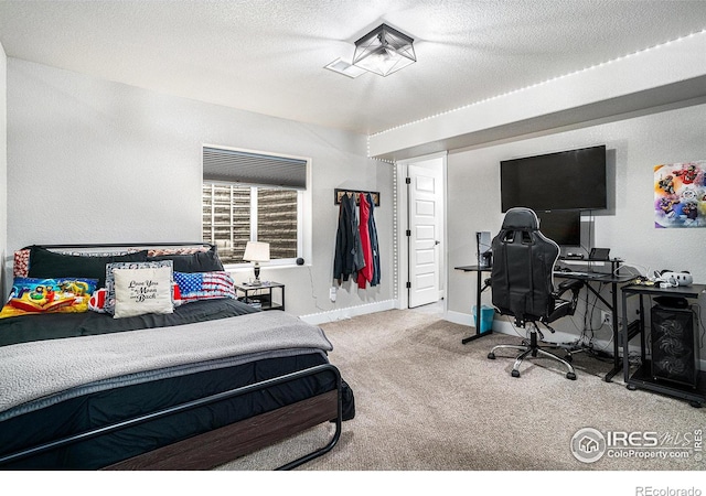 carpeted bedroom featuring a textured ceiling and baseboards