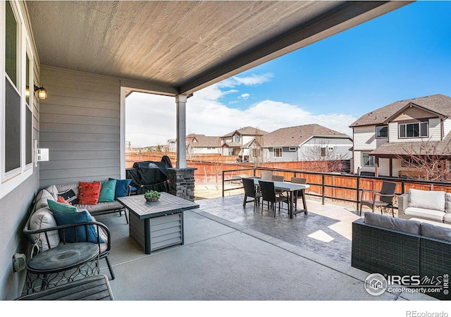 view of patio / terrace with a residential view, outdoor dining area, fence, and an outdoor hangout area