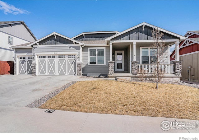 craftsman inspired home with covered porch, an attached garage, board and batten siding, driveway, and a front lawn