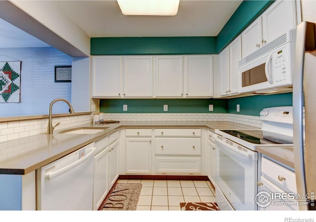 kitchen featuring a sink, white appliances, and white cabinetry