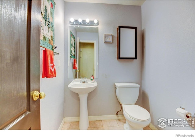 bathroom featuring tile patterned floors, toilet, and baseboards