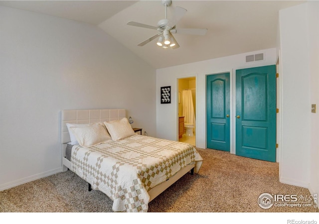 carpeted bedroom featuring visible vents, connected bathroom, baseboards, lofted ceiling, and a ceiling fan