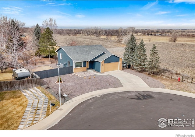 view of front of house with concrete driveway, fence, and an attached garage