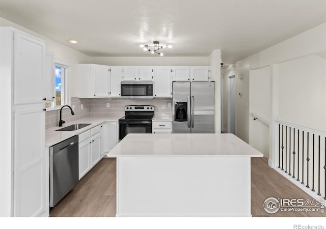 kitchen with appliances with stainless steel finishes, white cabinets, and a sink