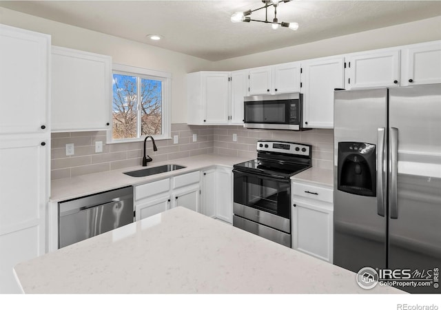 kitchen with white cabinetry, tasteful backsplash, appliances with stainless steel finishes, and a sink