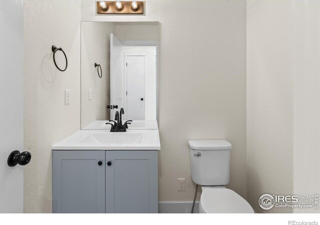 half bathroom featuring toilet and vanity