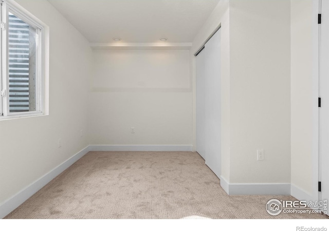 carpeted spare room with baseboards