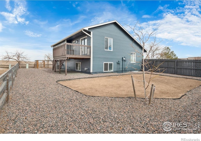 rear view of house with a fenced backyard, stairway, and a wooden deck