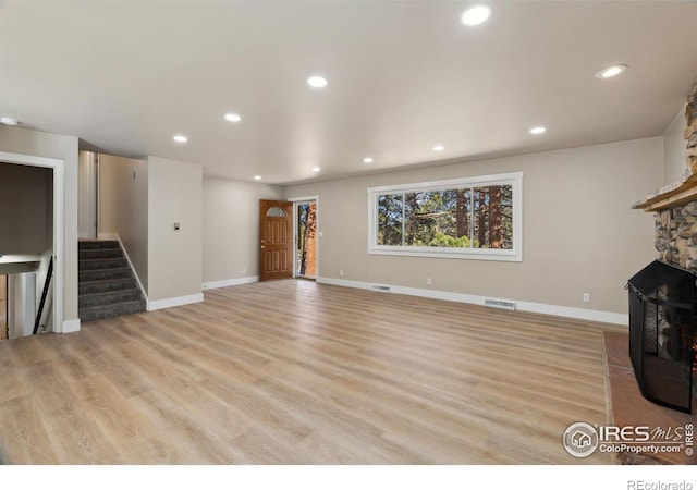 unfurnished living room with visible vents, recessed lighting, stairs, and light wood-style floors