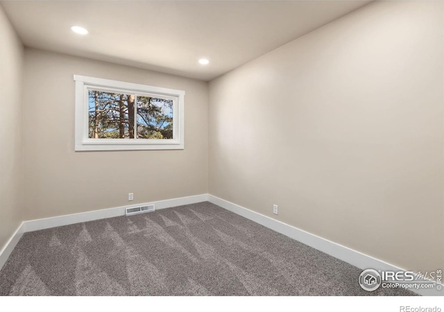 spare room with dark colored carpet, visible vents, baseboards, and recessed lighting