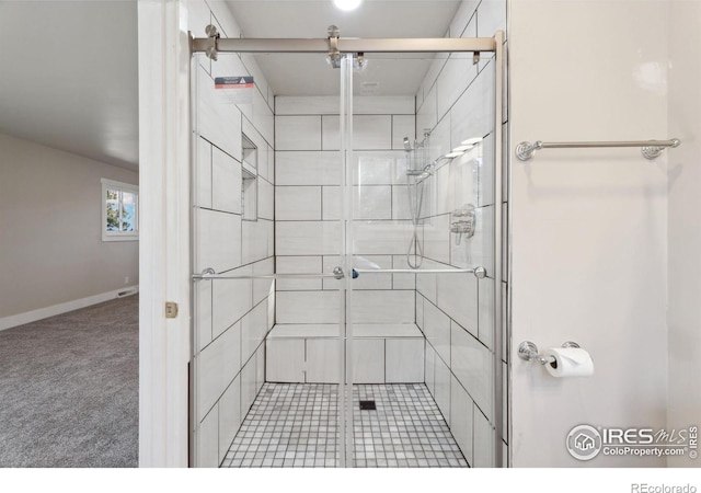 bathroom with baseboards and a stall shower