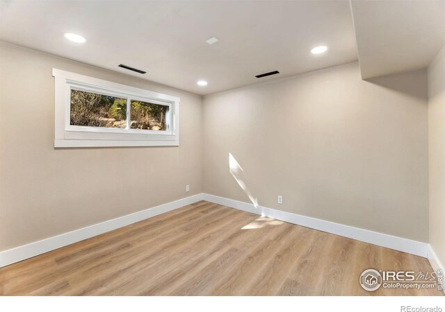 below grade area with visible vents, wood finished floors, and baseboards