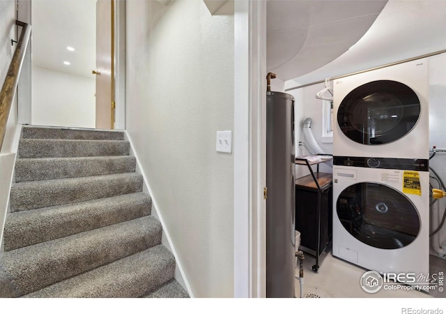 clothes washing area featuring recessed lighting, baseboards, and stacked washer / dryer