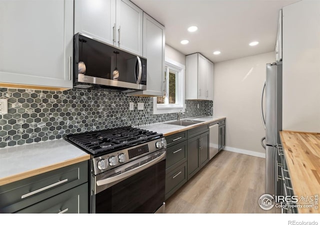 1059 Lexington Ln, Estes Park, CO 80517 - kitchen with stainless steel appliances, wood counters, light wood-style flooring, decorative backsplash, and a sink
