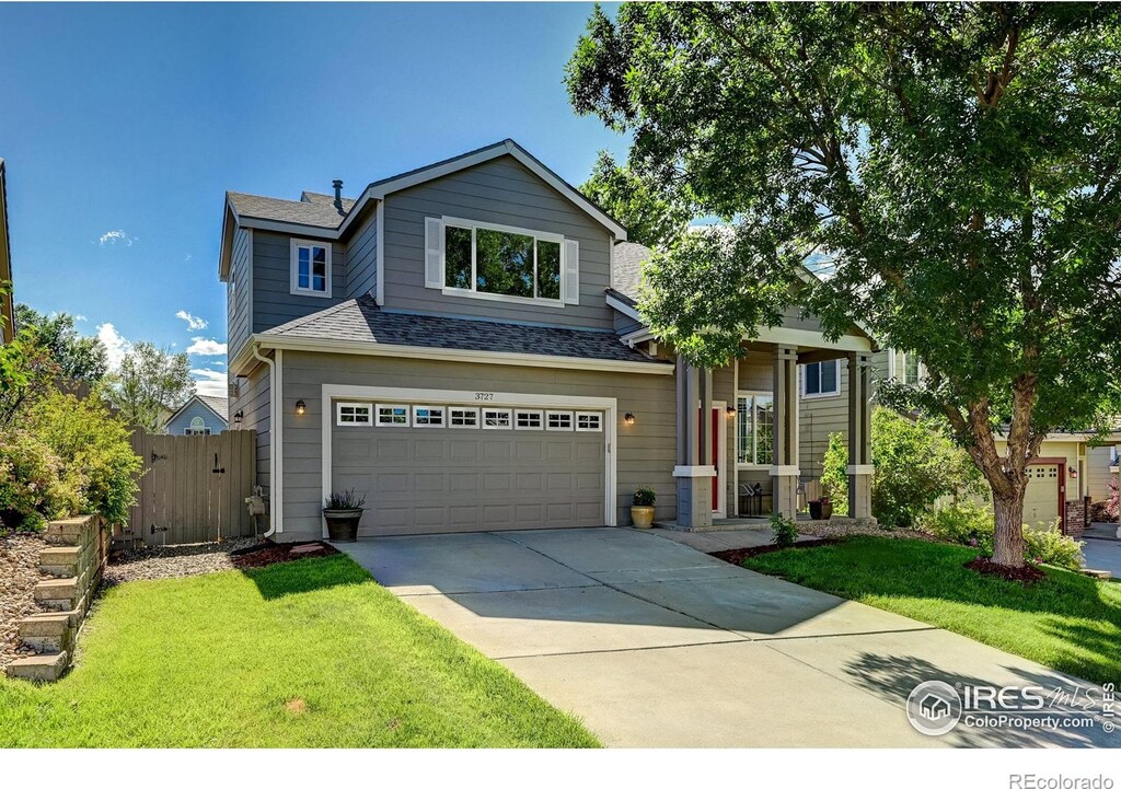 view of front of property featuring an attached garage, fence, driveway, roof with shingles, and a front lawn