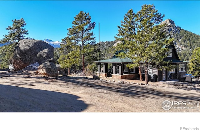 exterior space featuring a mountain view and dirt driveway