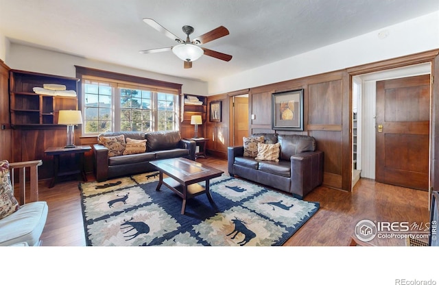 living area with ceiling fan and wood finished floors