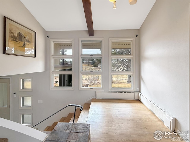 dining space featuring vaulted ceiling with beams, baseboard heating, and wood finished floors