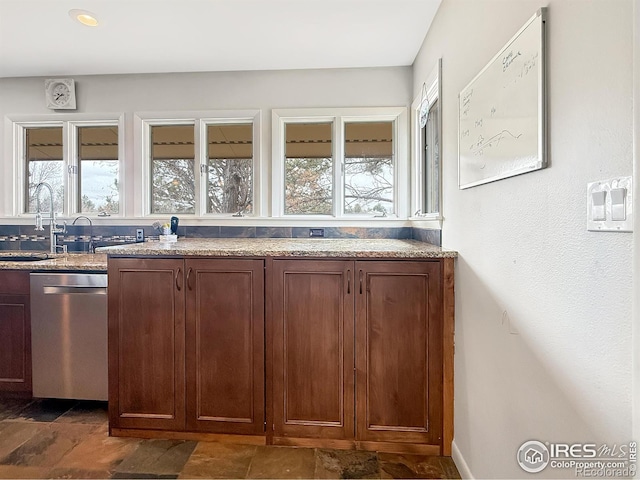 kitchen featuring a sink, light stone countertops, and dishwasher