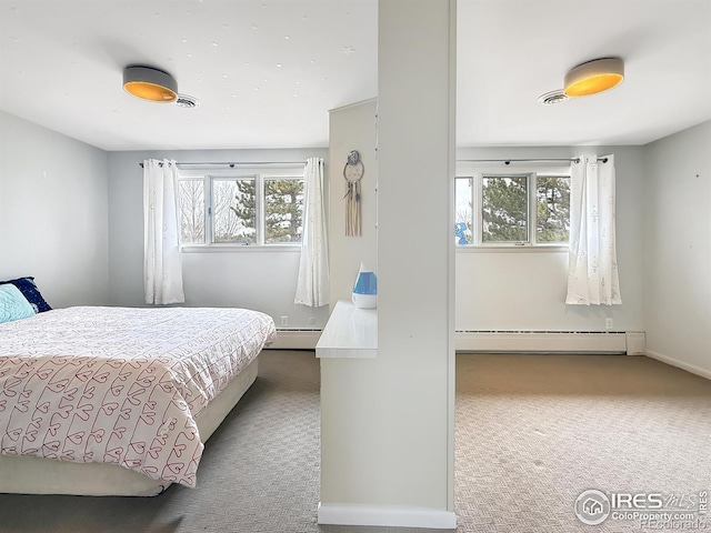 carpeted bedroom with a baseboard radiator, multiple windows, visible vents, and baseboard heating