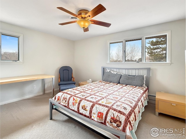 carpeted bedroom with a baseboard heating unit, ceiling fan, and baseboards