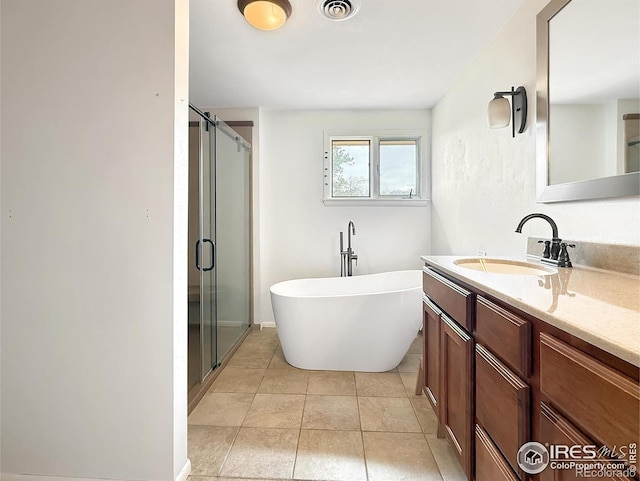 full bathroom with visible vents, vanity, a soaking tub, a shower stall, and tile patterned floors