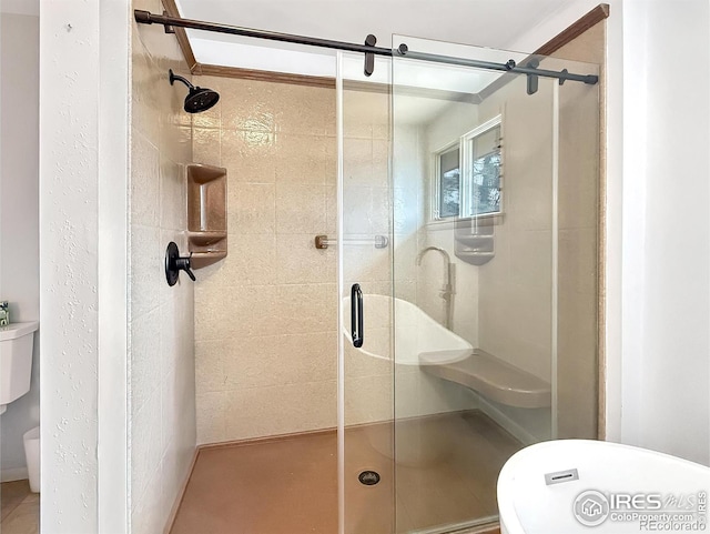 bathroom featuring toilet and a shower stall