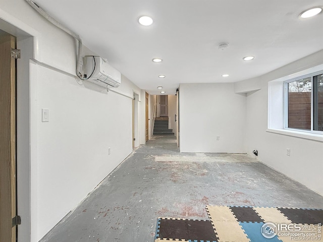 basement featuring an AC wall unit and recessed lighting