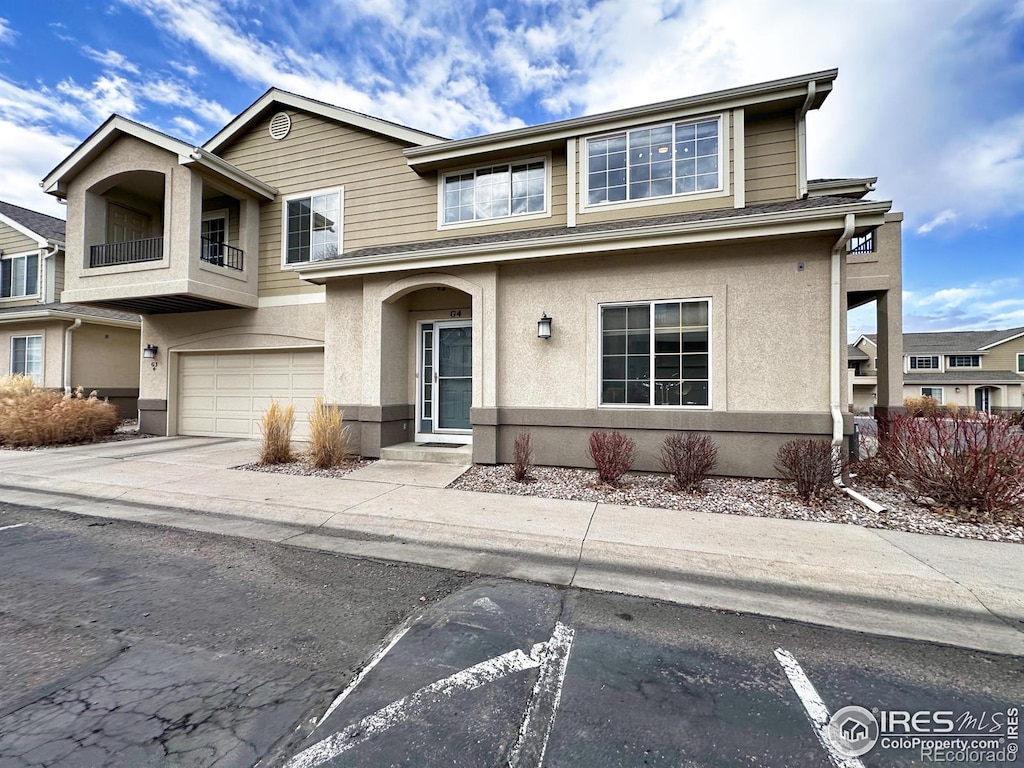 view of front of house with driveway, an attached garage, and stucco siding