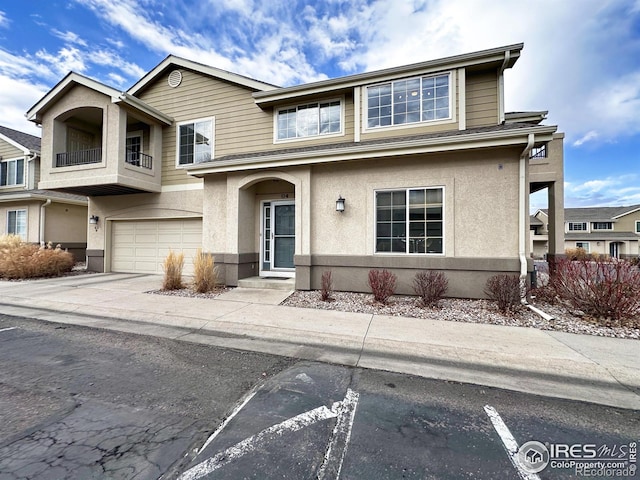 view of front of house with driveway, an attached garage, and stucco siding