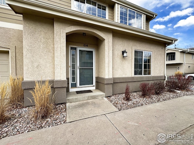 doorway to property featuring stucco siding